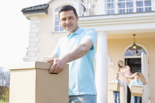Local movers carrying household items down stairs in Uxbridge